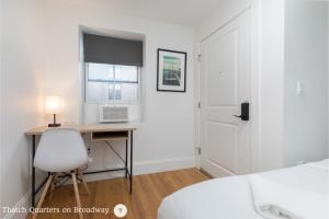 a bedroom with a desk and a bed and a window at West Broadway Quarters by Thatch in Boston