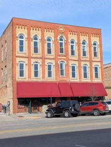 a large brick building with cars parked in front of it at Tanner Building in Bay City