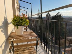 d'un balcon avec un banc en bois et une plante en pot. dans l'établissement Señorial Panorámico by Exclusive Burgos Apartments, à Burgos