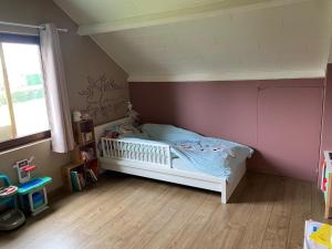 a childs bedroom with a bed and a window at bungalow des ardennes in Stavelot