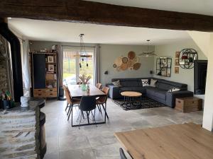 bungalow des ardennes في ستافيلو: غرفة معيشة مع طاولة وأريكة