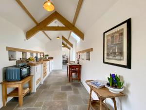 a kitchen with white walls and wooden beams at The Chicken Shed in Cold Ashton