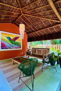 a patio with two chairs and a table and a painting at Pousada Pipa Soul in Pipa