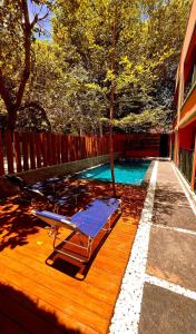 a swimming pool with a chaise lounge on a wooden deck at Pousada Pipa Soul in Pipa