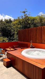 un bain à remous installé au-dessus d'une terrasse en bois dans l'établissement Pousada Pipa Soul, à Pipa