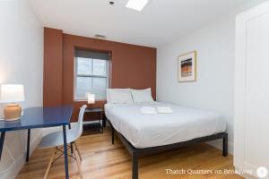 a bedroom with a bed and a desk and a table at West Broadway Quarters by Thatch in Boston