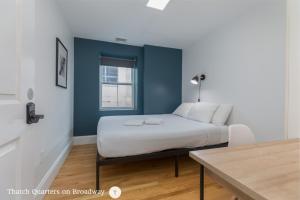 a bedroom with a bed with a blue accent wall at West Broadway Quarters by Thatch in Boston