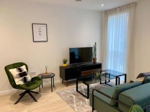 a living room with a couch and a tv at Luxury 1 bedroom East London in London