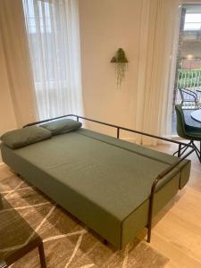 a green bed in a room with a table and chairs at Luxury 1 bedroom East London in London