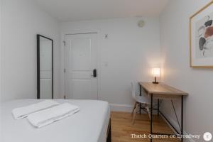 a bedroom with a bed and a desk with a lamp at West Broadway Quarters by Thatch in Boston