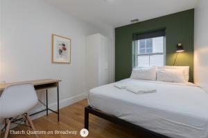 a bedroom with a bed and a desk and a window at West Broadway Quarters by Thatch in Boston