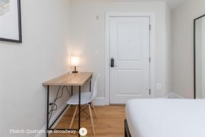 a bedroom with a desk and a chair and a door at West Broadway Quarters by Thatch in Boston