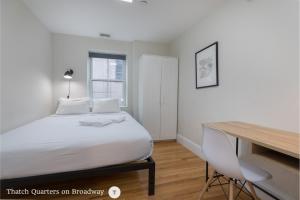 a bedroom with a bed and a desk and a desk at West Broadway Quarters by Thatch in Boston