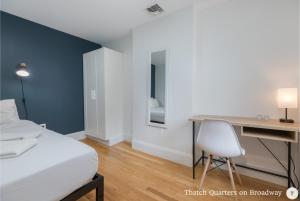 a bedroom with a bed and a desk and a chair at West Broadway Quarters by Thatch in Boston