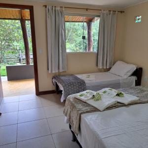 a hotel room with two beds and a window at Casa Nirvana para Temporadas in Alto Paraíso de Goiás