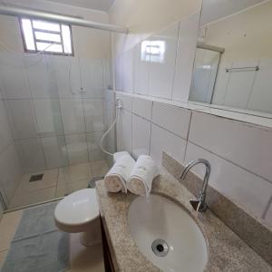 a bathroom with a sink and a toilet and a mirror at Casa Nirvana para Temporadas in Alto Paraíso de Goiás