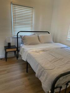 uma cama com lençóis brancos e almofadas num quarto em Dwell Seaview em Seaview