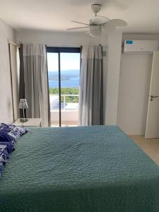 1 dormitorio con cama verde y vistas al océano en Terrazas de la comarca en La Cuesta