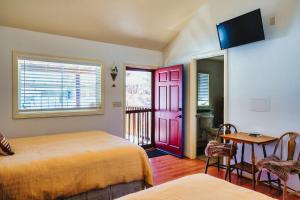 a bedroom with two beds and a red door at The Loubird Inn in Escalante
