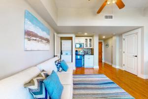 een woonkamer met een witte bank en blauwe kussens bij Sandestin Baytowne Wharf - Observation Point South #471 in Destin