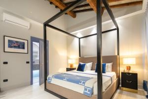 een slaapkamer met een hemelbed met blauwe kussens bij Firenze F1 in Florence