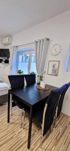 una mesa de comedor negra y sillas en una habitación en Apartment Mario, en Ptuj