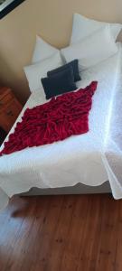 eine rote Decke auf einem weißen Bett in der Unterkunft Repose Guest house! in King Williamʼs Town