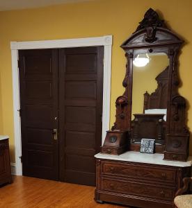 a room with a mirror and a dresser and a door at Oaklawn Inn in Menomonie