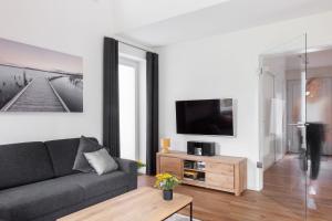 a living room with a couch and a tv at DOMIZIL AM SIEL "Reisen für Alle" in Fedderwarderdeich