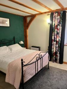 a bedroom with a bed and a green wall at Chez Jallot - Lower Gite in Vidaillat