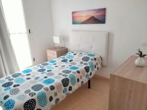 1 dormitorio con 1 cama con edredón azul y blanco en City Centre Arrecife, en Arrecife