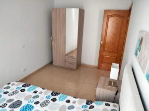 1 dormitorio con 1 cama y puerta de madera en City Centre Arrecife en Arrecife