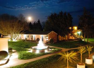 una casa con una fuente en el patio por la noche en Breezeway Resort en Westerly