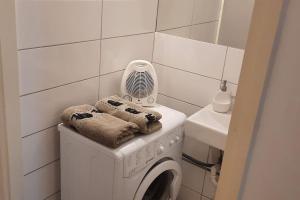 uma máquina de lavar roupa na casa de banho com uma ventoinha em Nice downtown apartment em Budapeste