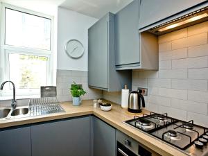 a kitchen with blue cabinets and a sink at 5 Devon Beach Court in Woolacombe