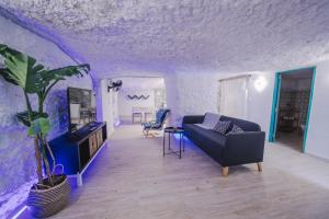 Sala de estar de color púrpura con sofá y TV en PRECIOSA CASA-CUEVA CON JACUZZI en Paterna