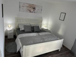 a white bedroom with a bed and two night stands at Golden Apartment Schwabach in Schwabach