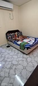 a bed in a room with a marble floor at Wummies place in Abu Dhabi