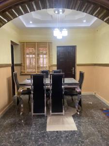 a dining room with a long table and chairs at S&Y Apartment in Ilesa