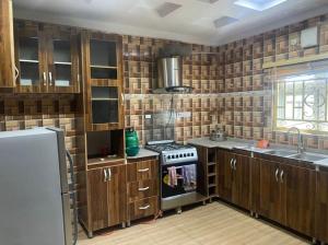 uma cozinha com armários de madeira e um forno com placa de fogão em S&Y Apartment em Ilesa
