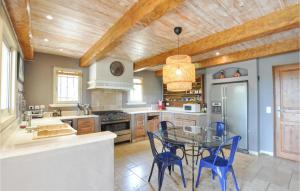 cocina con mesa de cristal y sillas azules en Nice Home In Fayence With Wifi, en Fayence