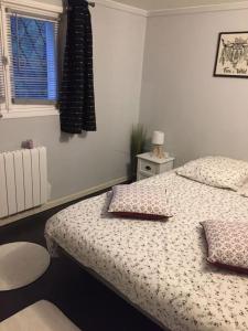 Un dormitorio con una cama con almohadas y una ventana. en t3 au rez de jardin d une maison, en Anglet 1 foto más