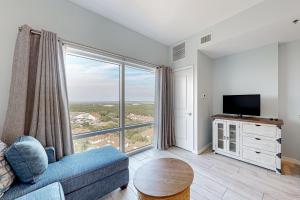 a living room with a blue couch and a large window at Luau Condos V in Destin