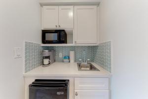 una pequeña cocina con fregadero y microondas en Luau Condos V en Destin