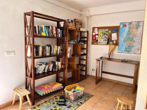 a room with a book shelf filled with books at A comfortable rural space in beautiful gardens in Oliveira do Hospital