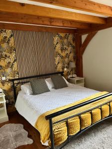 Chez Jallot - Upper Gite في Vidaillat: غرفة نوم بسرير كبير بسقف خشبي