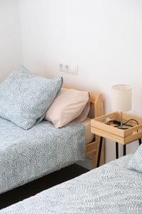 1 dormitorio con 2 camas y mesa con lámpara en AOVE Suite, en Jaén