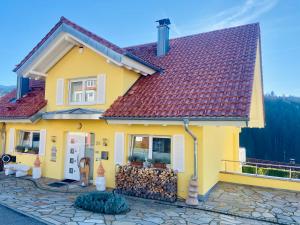 ein gelbes Haus mit rotem Dach in der Unterkunft Sonnenberg Resort in Elzach
