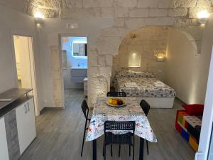 una habitación con una mesa con sillas y una cama en Casa trento, en Ostuni