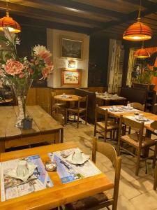 a restaurant with wooden tables and chairs and flowers at HOTEL Le TOURISME in Passy